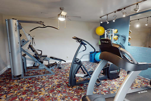 A gym room with a rowing machine and a stationary bike.