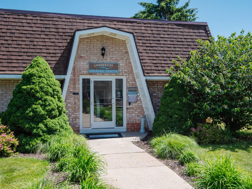 the front of a brick building leasing office with a glass door