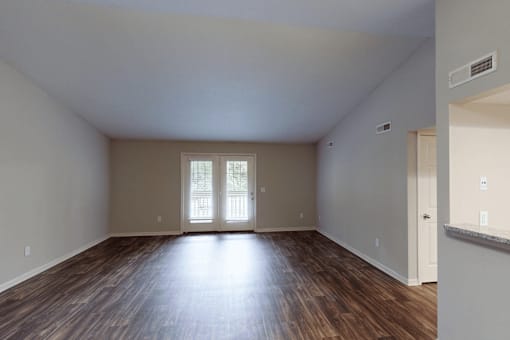 A room with wooden floors and a large window.