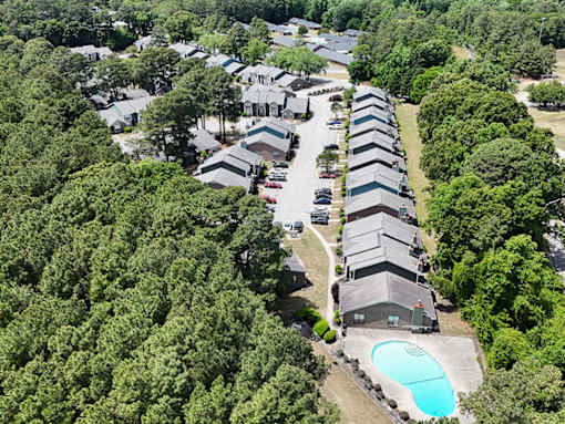 A bird's eye view of a residential area with houses and a swimming pool.