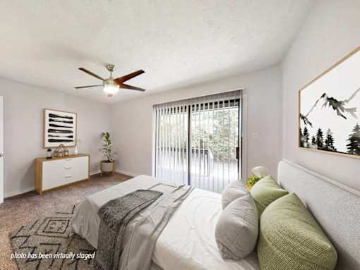 A bedroom with a bed, dresser, and window.
