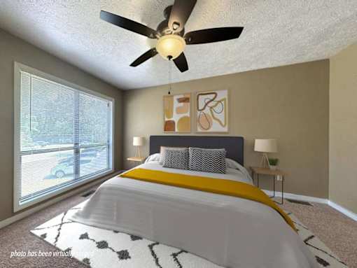A bedroom with a large bed and a ceiling fan.