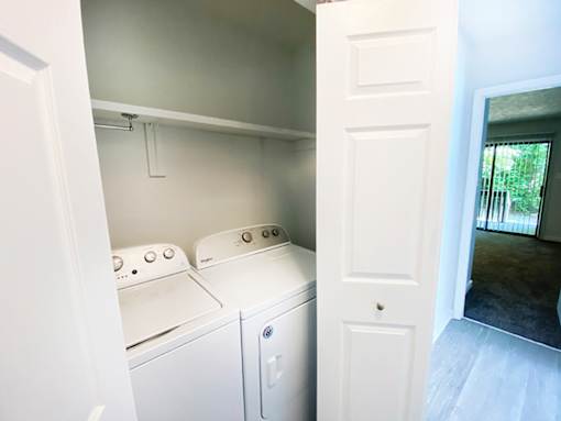 A white washing machine and dryer in a small laundry room.