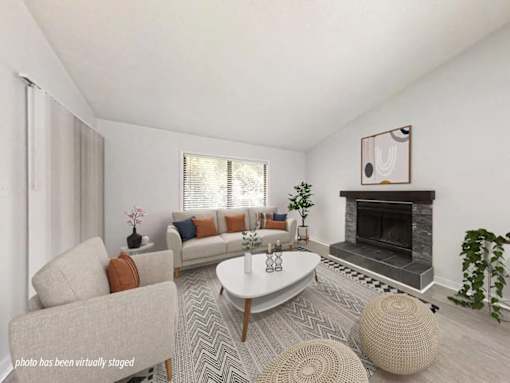 A living room with a grey sofa, a white coffee table, and a fireplace.