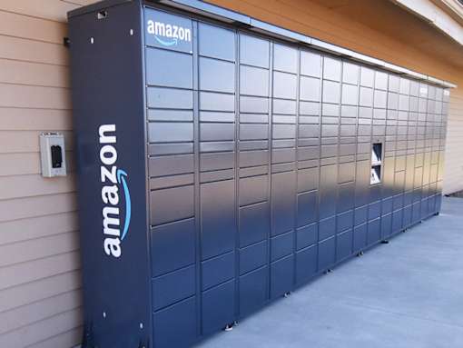 A large Amazon storage unit is parked in front of a building.