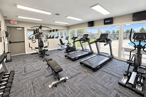 A gym with treadmills, weights, and exercise equipment.