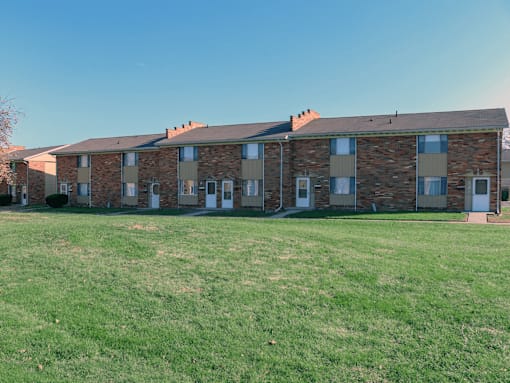 A row of houses with a green lawn in front.