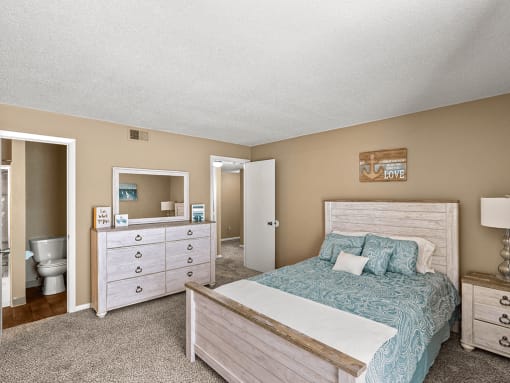 a bedroom with a bed and a bathroom with a toilet