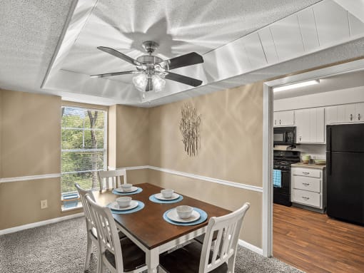 a dining room with a table and chairs and a ceiling fan