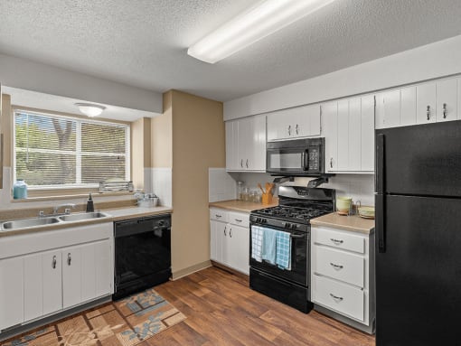 a kitchen with black appliances and white cabinets