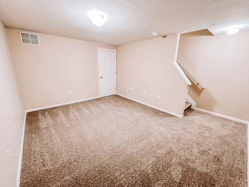 an empty room with carpeted floors and a white door
