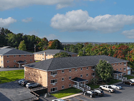 A large brick building with a parking lot in front.