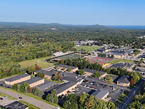 A large building complex with a parking lot in front of it.