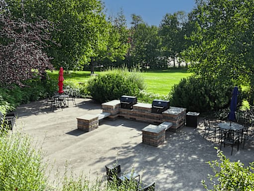 A backyard patio with a fire pit and seating area.