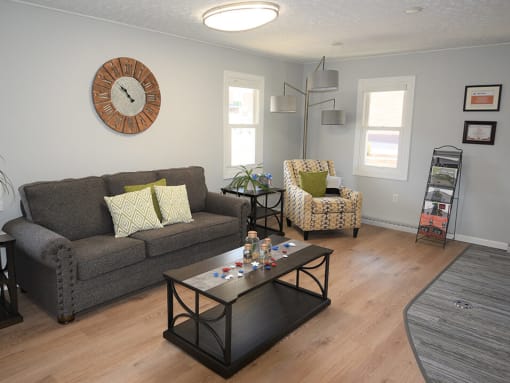 a living room with gray walls and a large clock on the wall