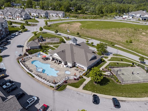 A large community clubhouse with a pool in front of it.