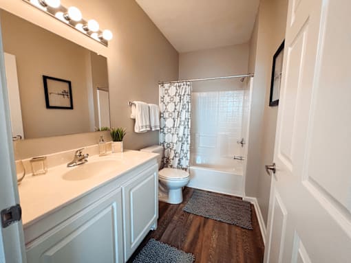 A spacious white bathroom with a toilet, sink, and shower.