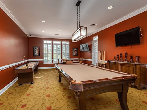 A pool table in a room with orange walls.