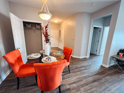 A dining room with a table set for two and two chairs.
