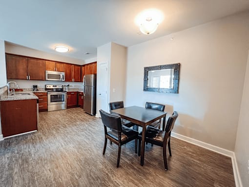 A kitchen with a dining table and chairs.