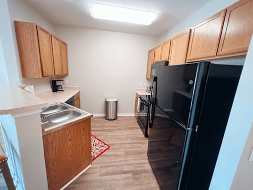 A kitchen with wooden cabinets and a black appliances.