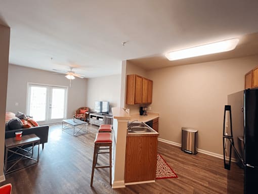 A kitchen with a breakfast bar and refrigerator, sink.