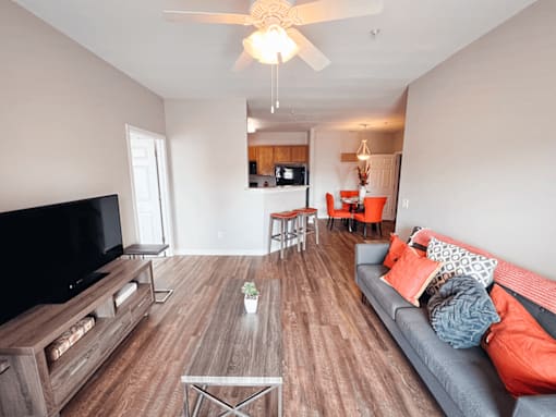 A living room with a grey couch and a wooden floor.