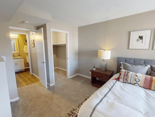 a bedroom with a bed and a bathroom with a mirror
