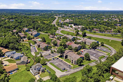 A bird's eye view of a residential area with houses and a parking lot.