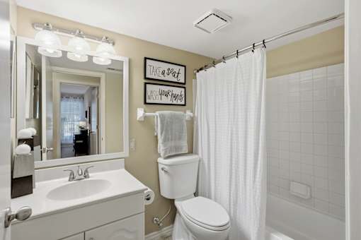A bathroom with a toilet, sink, and shower.