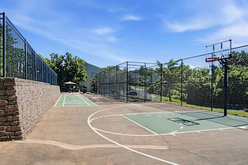 A basketball court surrounded by a black fence.