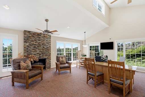 A living room with a stone fireplace and a television.