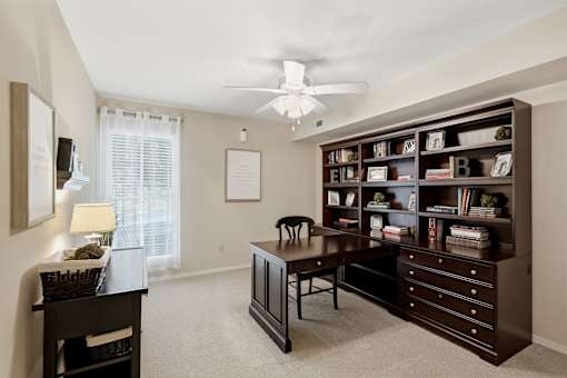 A room with a desk, chair, and bookshelf.