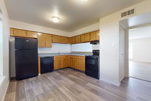 A kitchen with black appliances and wooden cabinets.