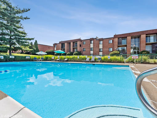 a large swimming pool with an apartment building in the background