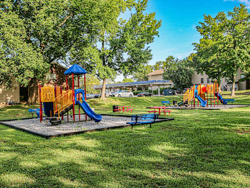 A playground with a blue slide and a yellow and red play structure.