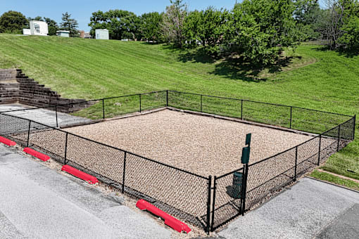 A dog park surrounded by a black fence with red trim.