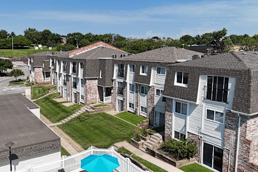 A row of apartment buildings with a pool in the foreground.