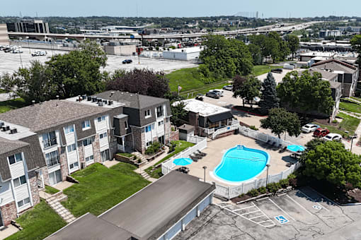 A large apartment complex with a pool and a parking lot.