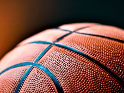 A close up of a basketball with a focus on the textured surface and the blue lines.