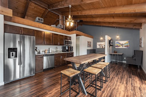 A kitchen with a wooden table and stools.