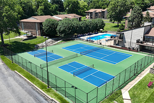 Tennis and pickleball courts surrounded by a fence.