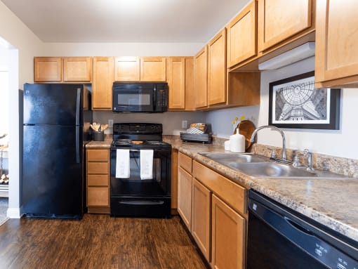 a kitchen with black appliances and wooden cabinets