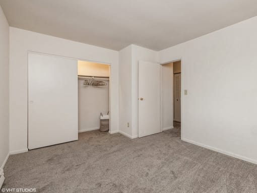 an empty bedroom with white walls and a closet
