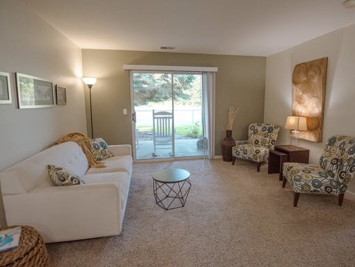a living room with a couch and chairs and a sliding glass door