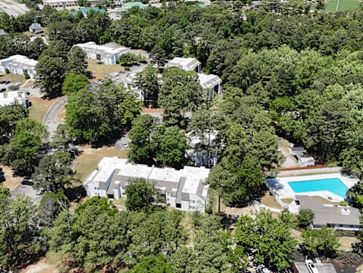 A bird's eye view of a residential area with a swimming pool.