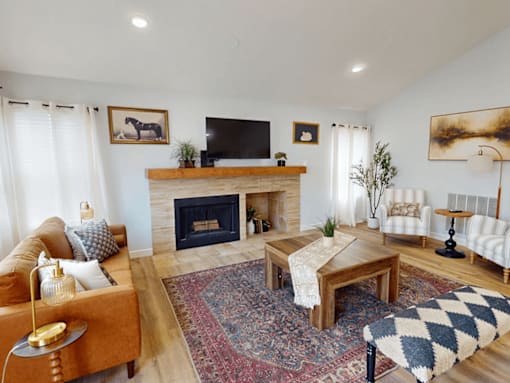A living room with a fireplace and a television on the wall.