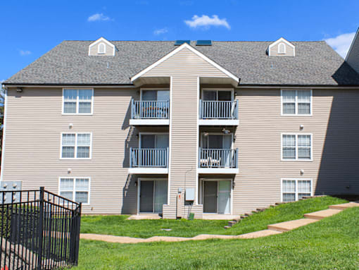 A large apartment building with a black gate in front.