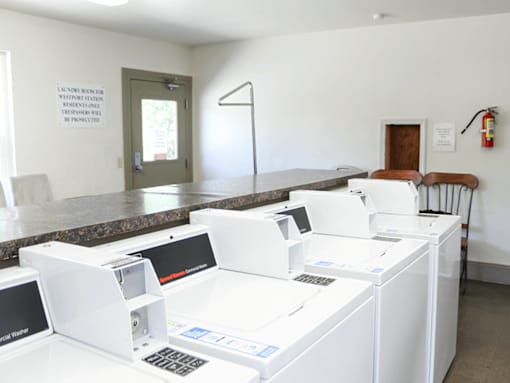 A laundromat with washing machines and a sign that says