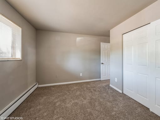 apartment bedroom with a closet and a door